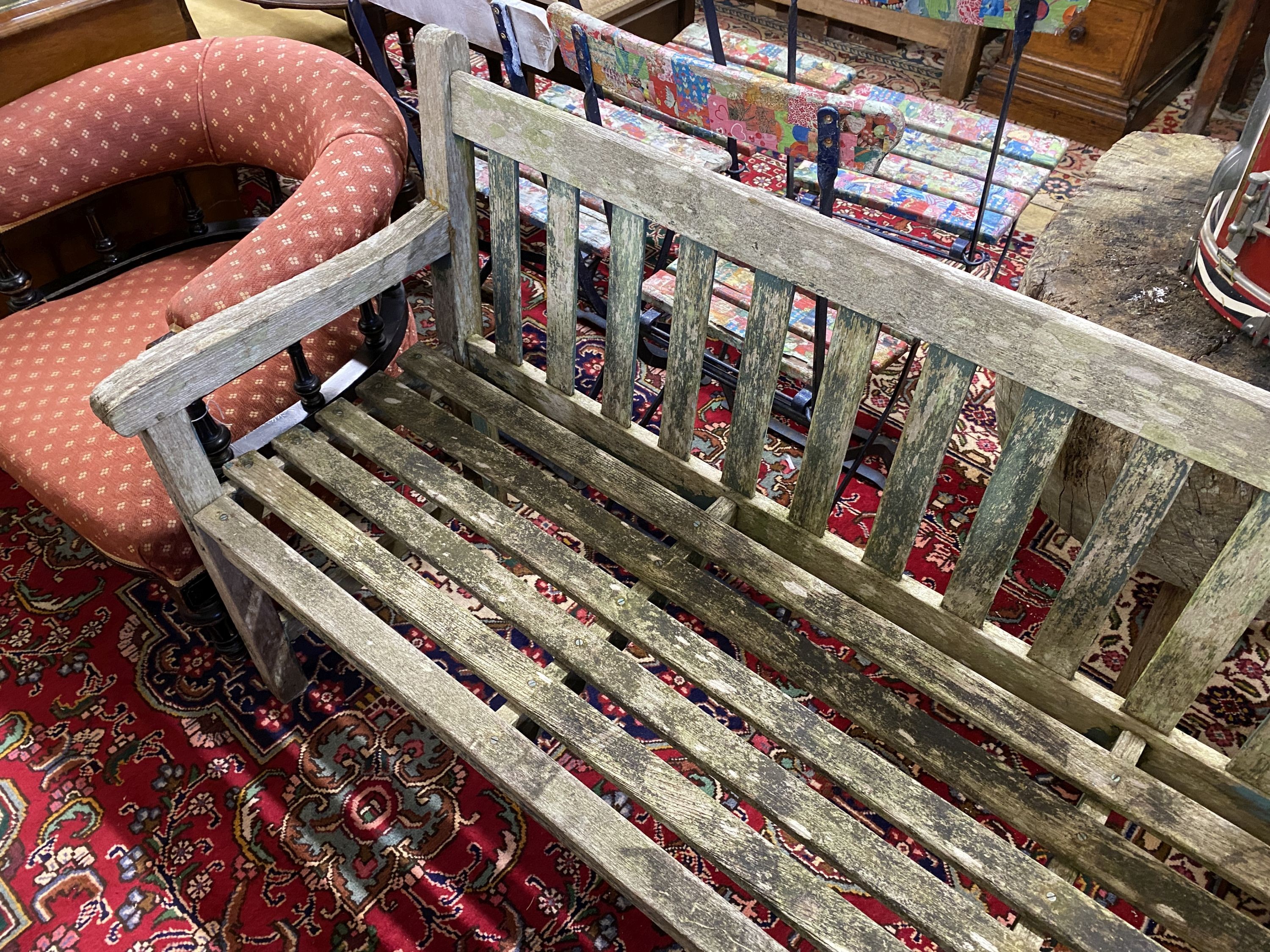 A weathered teak garden bench, length 153cm, depth 52cm, height 83cm